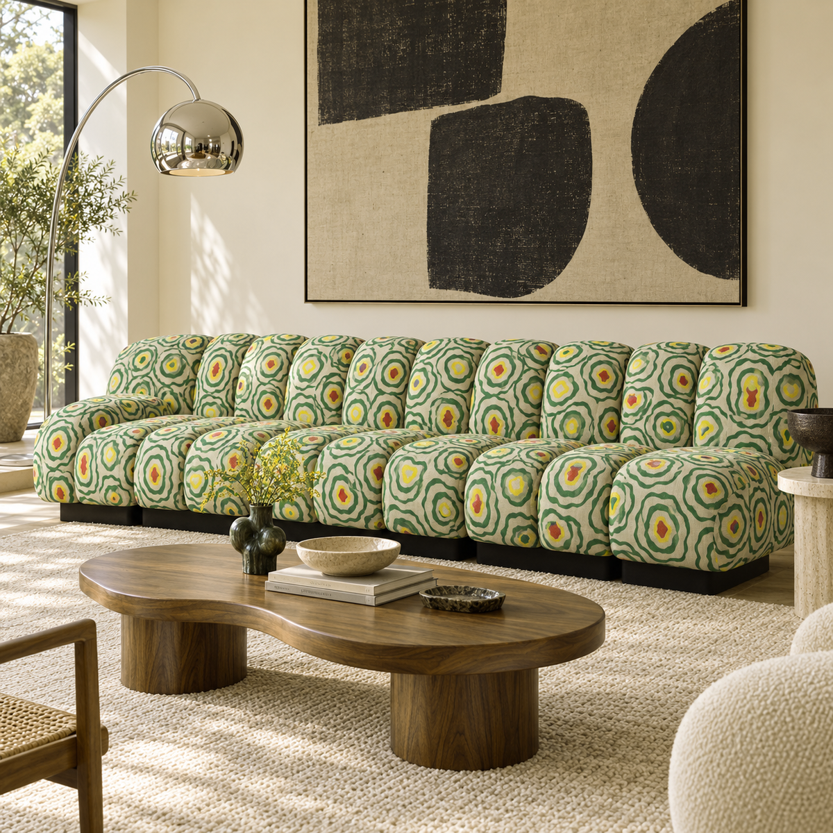 A modern sectional sofa with a green, yellow, and orange circular patterned upholstery, styled in a bright living room with a wooden coffee table and a large abstract wall art piece.